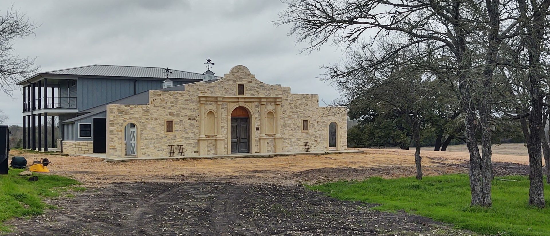 The Alamo Wall replica and barndominium with living quarters seen across the property near Fayetteville, built by Cross Creek