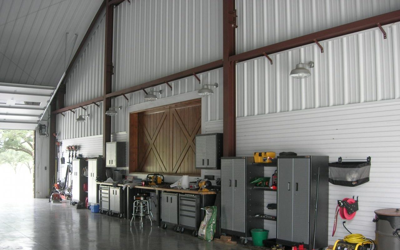 Barndominium shop bay with tool storage and roll-up door, built by Cross Creek