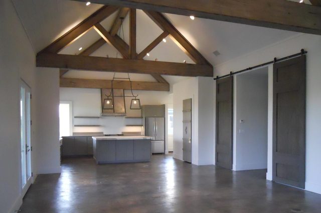 Casita open living room and kitchen with timber trusses and barn door