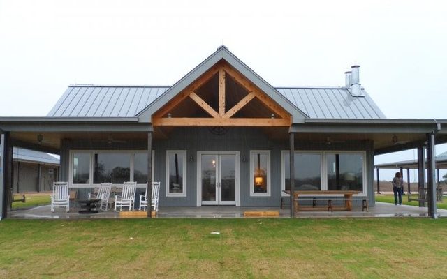 Barndominium porch with a cedar timber truss built by Cross Creek