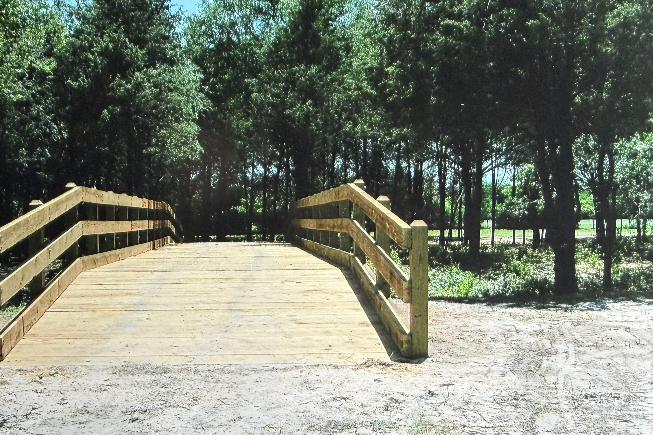 Timber bridge with post and rail sides on a ranch road, built by Cross Creek