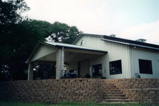 Horse stable with living quarters and a stone retaining wall