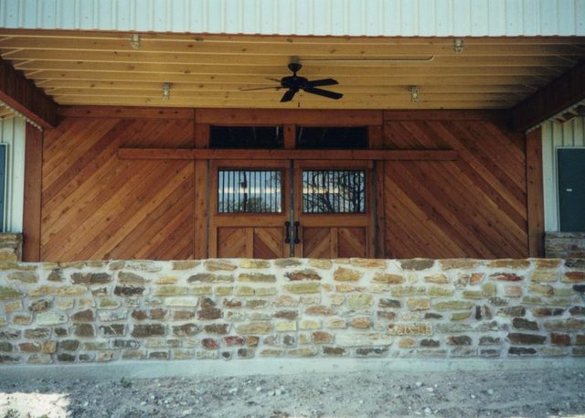 Stone and cedar stable entrance with wood doors